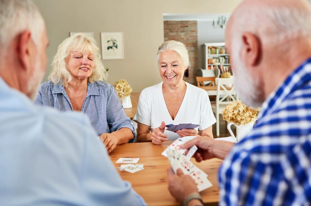 Senioren spielen gemeinsam Karten an einem Tisch